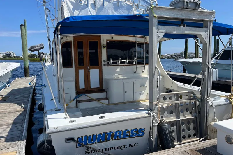 Slide: The Image of 1989 Topaz 44 Sportfisherman boat docked at marina with blue canopy. - 4
