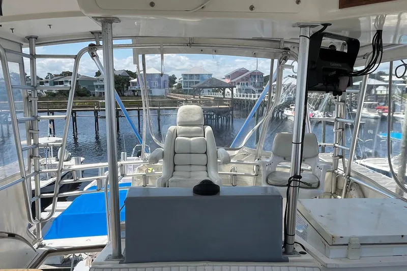 Slide: The Image of 1989 Topaz 44 Sportfisherman helm with Garmin navigation, overlooking marina and waterfront homes. - 9
