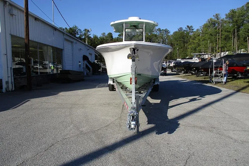 Slide: The Image of 2026 Sea Pro 292 Offshore boat on trailer at dealership, surrounded by trees and other boats. - 4