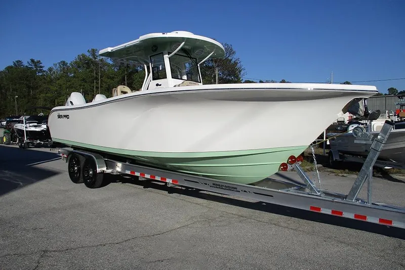 Slide: The Image of 2026 Sea Pro 292 Offshore boat on trailer, parked outdoors under clear blue sky. - 5