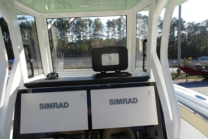 Slide: The Image of 2026 Sea Pro 292 Offshore boat dashboard with Simrad electronics and outdoor view. - 50