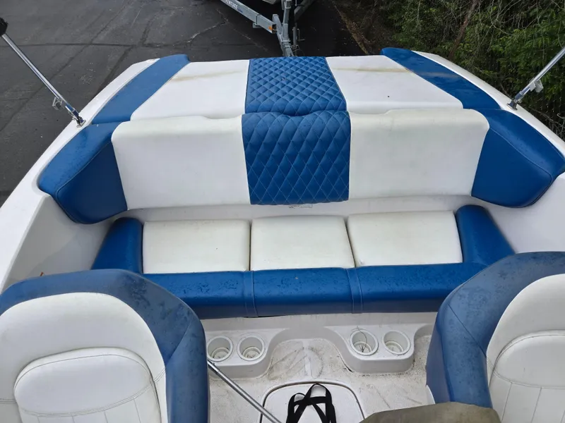 Slide: The Image of 2004 Yamaha Boats 210 LX interior with blue and white seating, cup holders, and quilted design. - 11