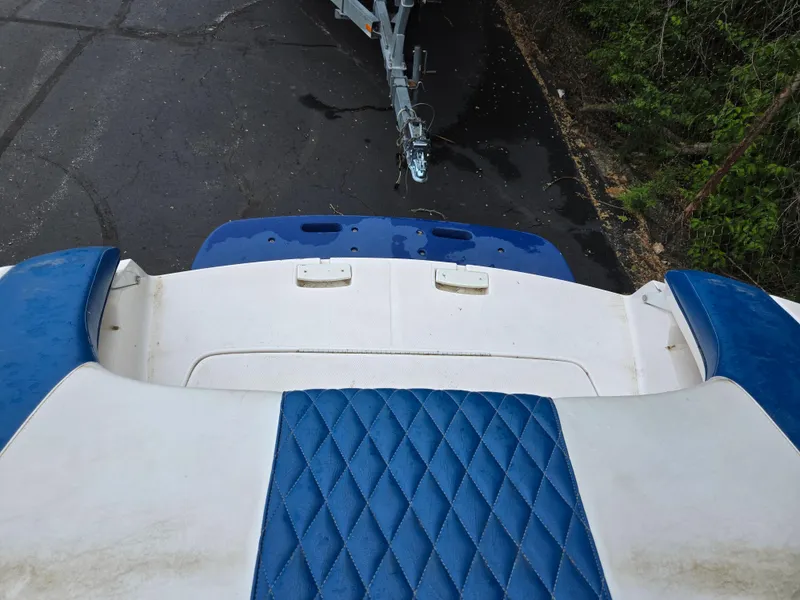 Slide: The Image of 2004 Yamaha Boats 210 LX interior with blue and white seating, trailer visible. - 13