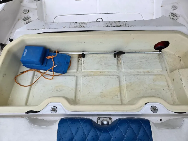 Slide: The Image of Storage compartment of a 2004 Yamaha Boats 210 LX with blue cushion and equipment. - 14