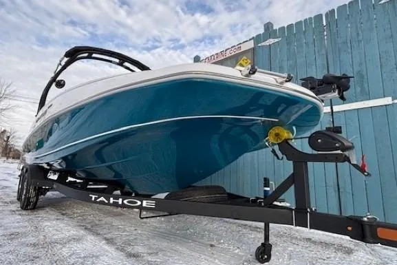 Slide: The Image of 2025 Tahoe 2150 boat on trailer, blue hull, parked on snowy ground. - 2