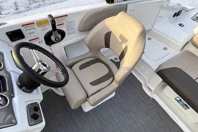 Slide: The Image of 2025 Tahoe 2150 boat interior with steering wheel and beige captain's chair. - 24