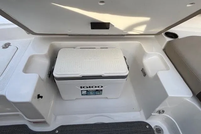 Slide: The Image of 2025 Tahoe 2150 boat storage compartment with Igloo cooler. - 32