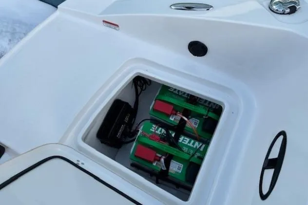 Slide: The Image of 2025 Tahoe 2150 boat battery compartment with dual green batteries and wiring. - 34
