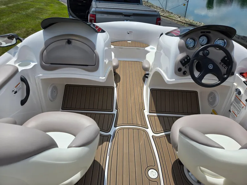 Slide: The Image of 2001 Yamaha LS 2000 boat interior with steering wheel and seating, docked near water. - 11