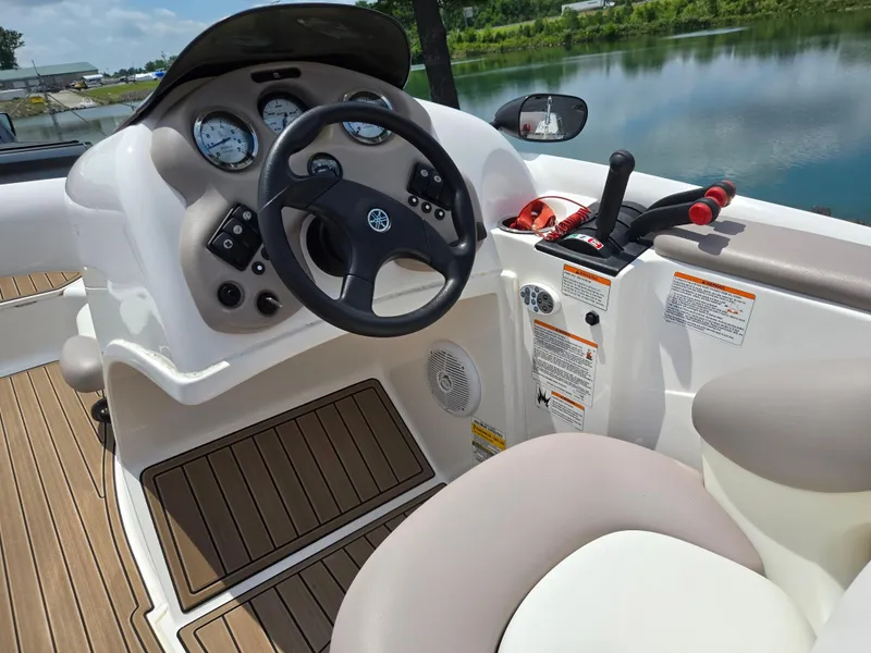 Slide: The Image of 2001 Yamaha Boats LS 2000 cockpit with steering wheel and controls by a serene lake. - 14