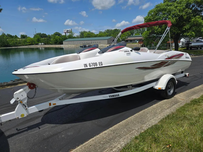 Slide: The Image of 2001 Yamaha LS 2000 boat on trailer by a lake under a blue sky. - 8