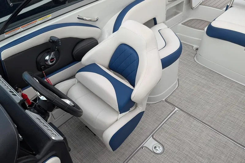 Slide: The Image of 2022 Crownline 260 XSS boat interior with blue and white seating and steering wheel. - 11