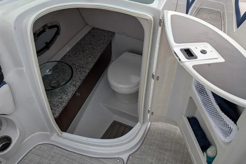 Slide: The Image of 2022 Crownline 260 XSS boat interior with compact bathroom and granite countertop. - 14