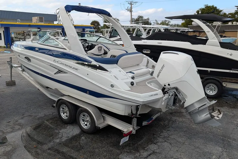 Slide: The Image of 2022 Crownline 260 XSS boat on trailer, featuring a Mercury outboard motor. - 2