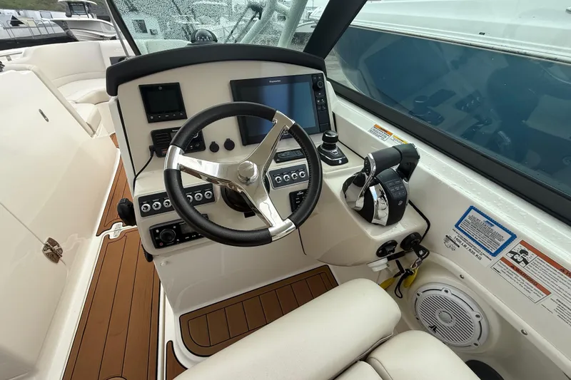 Slide: The Image of 2018 Boston Whaler 270 Vantage helm with steering wheel, controls, and navigation display. - 11