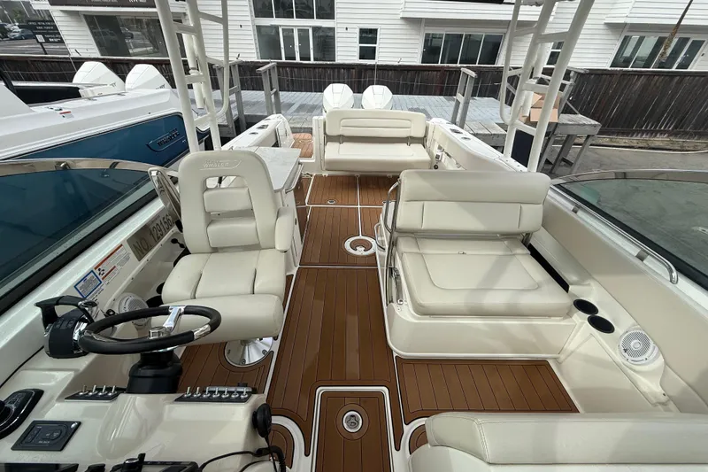 Slide: The Image of 2018 Boston Whaler 270 Vantage boat interior with white seating and wood flooring. - 12