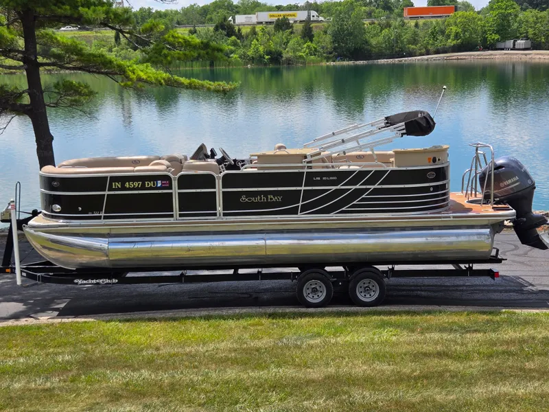 Slide: The Image of 2014 South Bay 522 E pontoon boat on trailer by a scenic lake. - 0