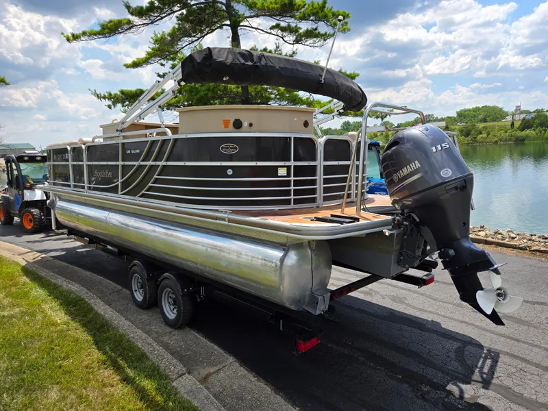 Slide: The Image of 2014 South Bay 522 E pontoon boat with Yamaha 115 engine on a trailer by a lake. - 1