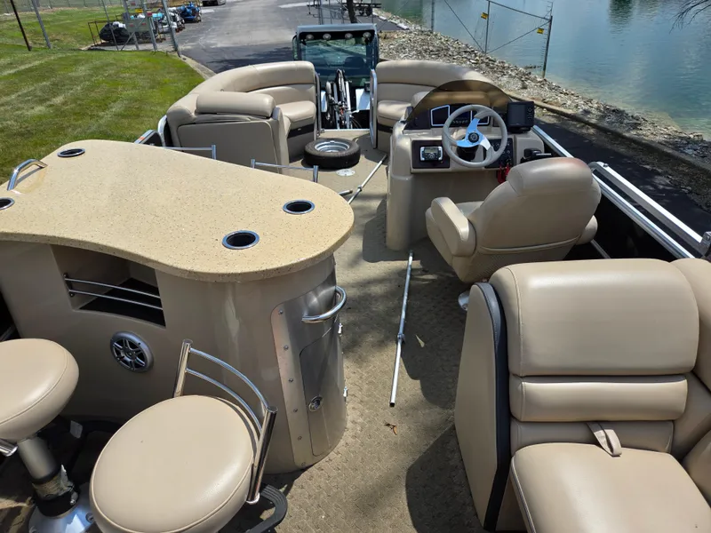 Slide: The Image of Luxurious 2014 South Bay 522 E pontoon boat interior with beige seating and helm. - 21