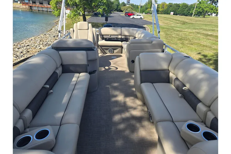 Slide: The Image of 2024 Sun Tracker Party Barge 20 DLX with spacious seating and cup holders by the water. - 11