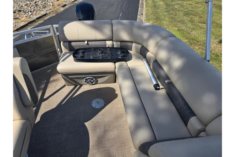 Slide: The Image of 2024 Sun Tracker Party Barge 20 DLX interior with beige seating and table. - 17