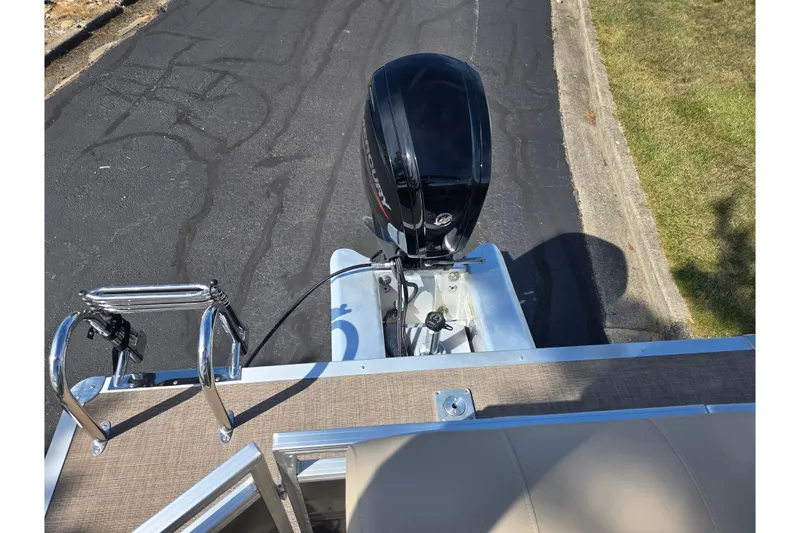 Slide: The Image of 2024 Sun Tracker Party Barge 20 DLX with outboard motor on a paved road. - 18
