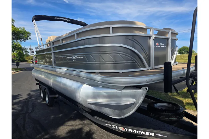 Slide: The Image of 2024 Sun Tracker Party Barge 20 DLX pontoon boat on trailer, parked outdoors. - 5