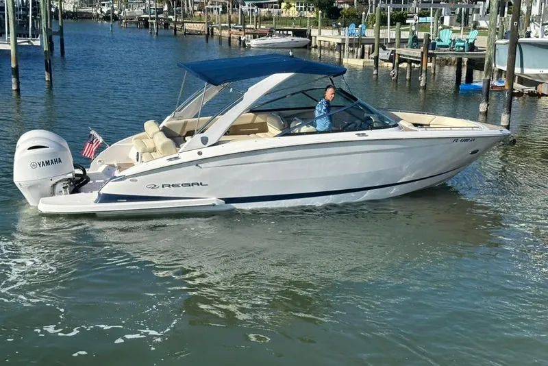 Slide: The Image of 2019 Regal 29 OBX boat with Yamaha engine cruising in a marina. - 12