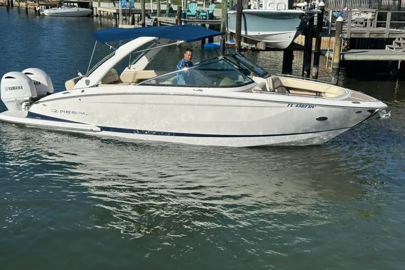 Slide: The Image of 2019 Regal 29 OBX boat with Yamaha engines on a calm waterway. - 13
