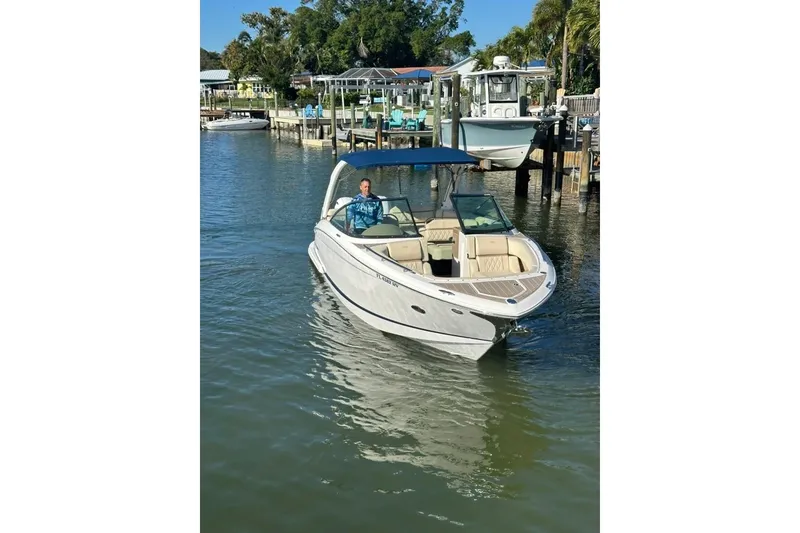 Slide: The Image of 2019 Regal 29 OBX boat cruising on a sunny day near a dock. - 15