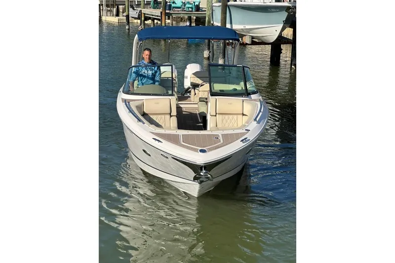 Slide: The Image of 2019 Regal 29 OBX boat with blue canopy on calm water. - 16