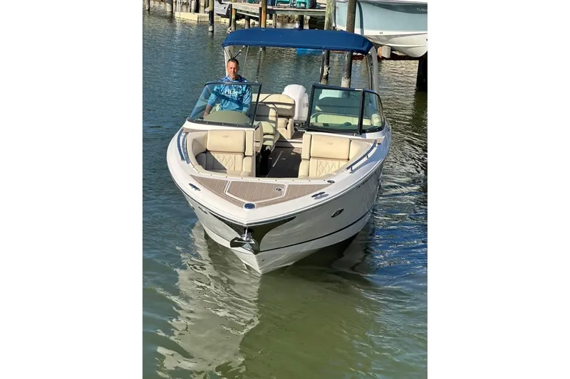 Slide: The Image of 2019 Regal 29 OBX boat with blue canopy on calm water. - 17