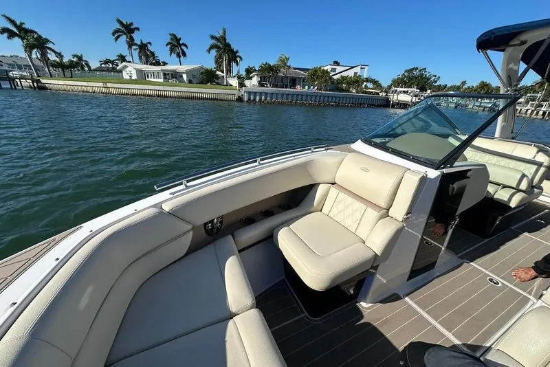Slide: The Image of 2019 Regal 29 OBX boat with luxurious seating on a sunny waterfront. - 22