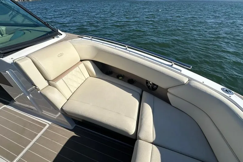 Slide: The Image of 2019 Regal 29 OBX boat interior with beige seating, on calm water. - 23
