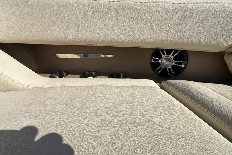 Slide: The Image of 2019 Regal 29 OBX boat interior with beige seating, cup holders, and speaker. - 25