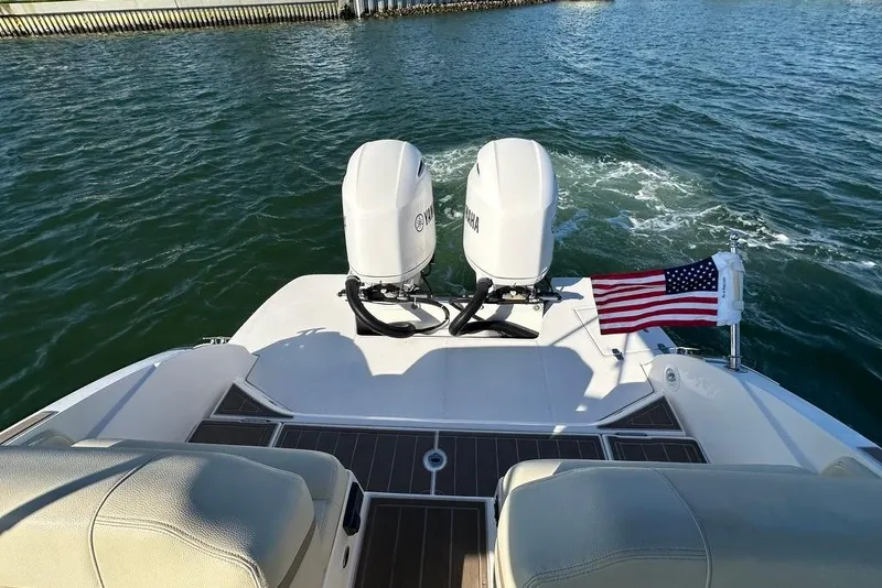 Slide: The Image of 2019 Regal 29 OBX boat with dual Yamaha engines and American flag on water. - 26