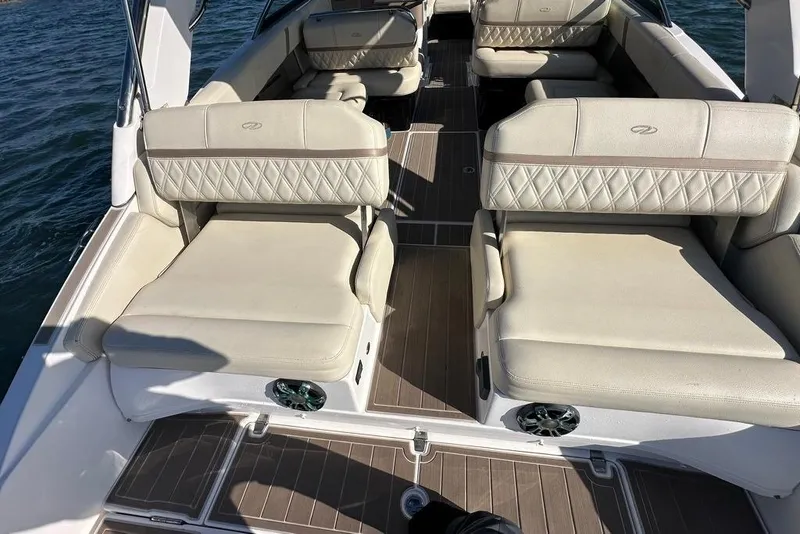 Slide: The Image of 2019 Regal 29 OBX boat interior with beige seating and wood flooring on the water. - 29