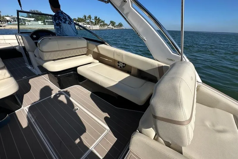 Slide: The Image of 2019 Regal 29 OBX boat interior with beige seating, on calm water. - 34