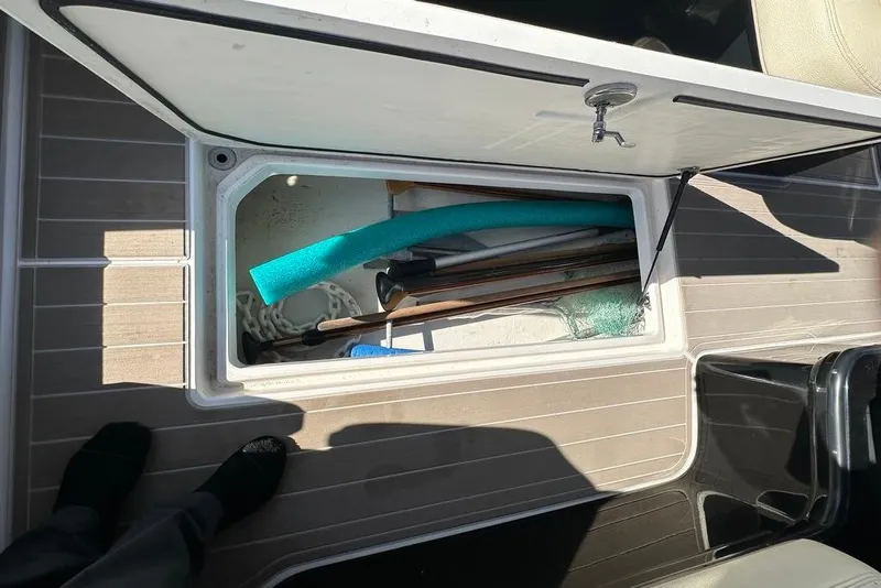 Slide: The Image of Open storage compartment on 2019 Regal 29 OBX boat with various items inside. - 39