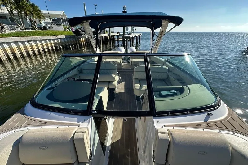 Slide: The Image of 2019 Regal 29 OBX boat docked by the water, showcasing spacious seating and sleek design. - 40
