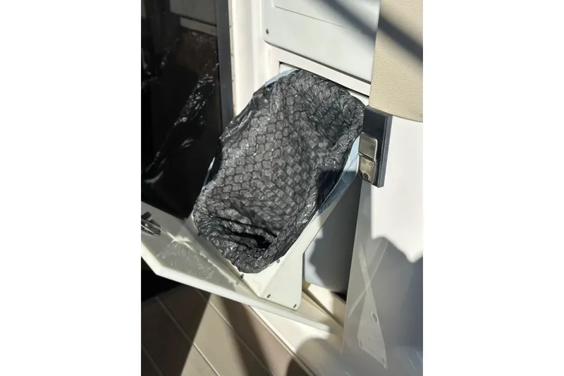 Slide: The Image of 2019 Regal 29 OBX boat trash compartment with open lid and liner. - 51