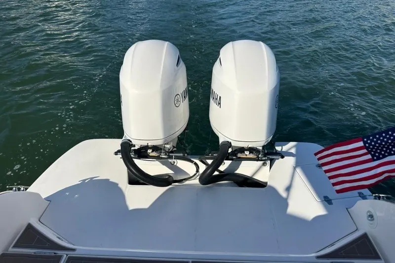 Slide: The Image of 2019 Regal 29 OBX boat with twin Yamaha outboard engines and American flag. - 68