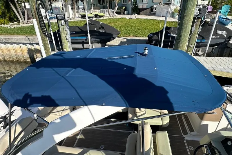 Slide: The Image of 2019 Regal 29 OBX boat with blue canopy docked near jet skis. - 75