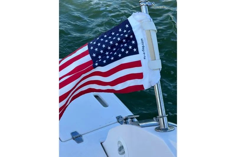 Slide: The Image of American flag on 2019 Regal 29 OBX boat, waving over water. - 77