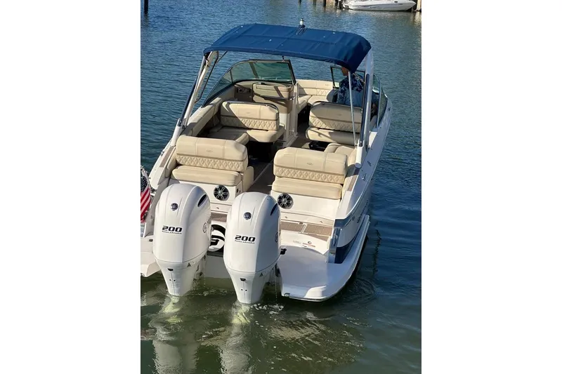 Slide: The Image of 2019 Regal 29 OBX boat with dual 200 horsepower engines, docked on calm water. - 8