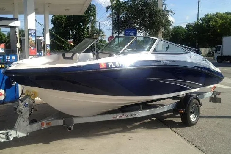 Slide: The Image of 2014 Yamaha SX190 boat on trailer at gas station. - 16