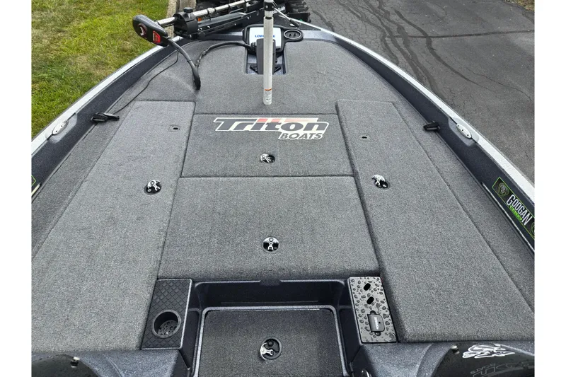 Slide: The Image of 2014 Triton 19XS boat deck with fishing rod holder and storage compartments. - 17