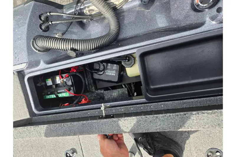 Slide: The Image of 2014 Triton 19XS boat battery compartment with wiring and NOCO Genius charger. - 24