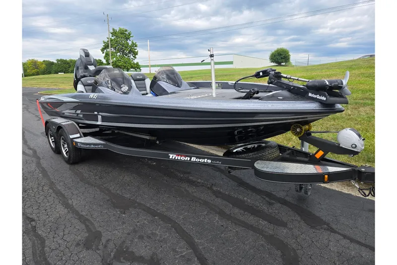 Slide: The Image of 2014 Triton 19XS boat on trailer, parked on asphalt, with cloudy sky background. - 5