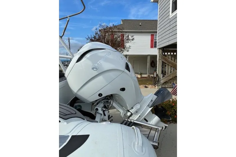 Slide: The Image of Highfield Sport 520 boat with Tohatsu outboard motor, 2021 model, parked near a house. - 10